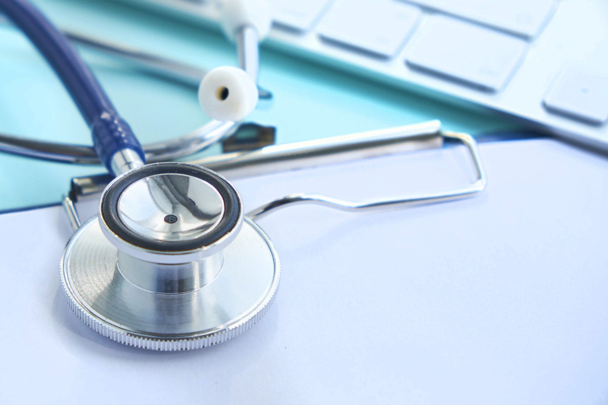 Stethoscope with clipboard and Laptop on desk,Doctor working in hospital writing a prescription.